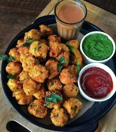 a plate full of food with sauces and condiments next to it on a wooden table