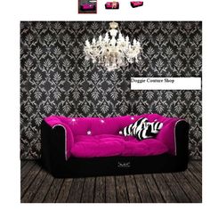 a black and pink couch sitting on top of a wooden floor next to a chandelier