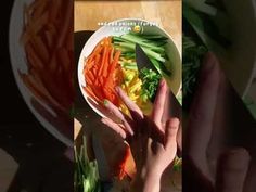 a person cutting up vegetables on top of a white plate