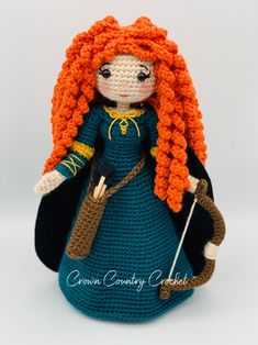 a crocheted doll with long red hair and blue dress is holding a cane