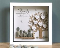 a family tree made out of rocks sitting on top of a table next to a teddy bear