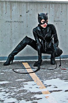 a woman dressed as catwoman crouching on the ground