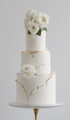 a three tiered cake with white flowers on top