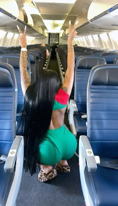 a woman with long black hair sitting on an airplane