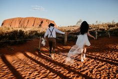 two people walking in the desert holding hands