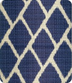 an upholstered blue and white area rug with diamond shapes on it's sides