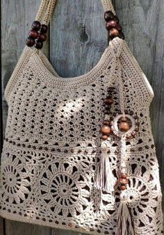 a crocheted bag with tassels and beads hanging from it's handle