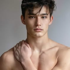 a shirtless young man with his arms crossed