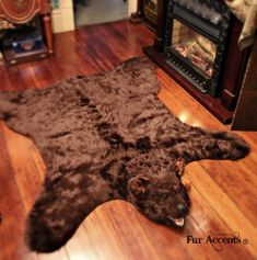 a brown bear rug on the floor in front of a fireplace