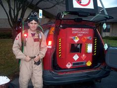 a man standing next to a car with its trunk open