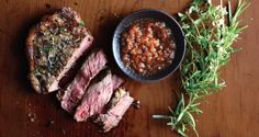 steak, beans and herbs on a wooden table