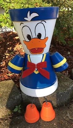 a blue and white donald ducky planter sitting on top of a stone wall