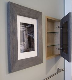 a bathroom with a sink, toilet paper dispenser and pictures on the wall