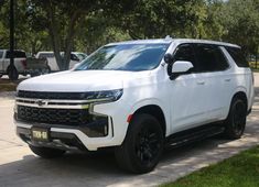 a white suv parked on the side of a road