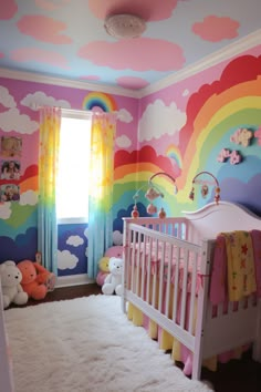 a baby's room with rainbow painted on the walls and teddy bears in the crib