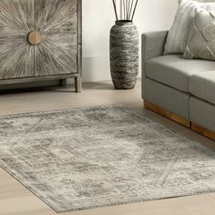 a living room with a gray couch and white rug