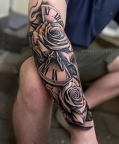 a man with a clock and roses tattoo on his arm is sitting in a chair