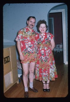 two people standing next to each other on a hard wood floored room with blue walls