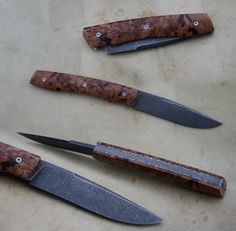 three knives sitting next to each other on top of a table with holes in them