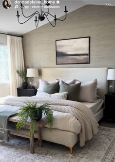 a bedroom with a large bed and chandelier hanging from it's ceiling