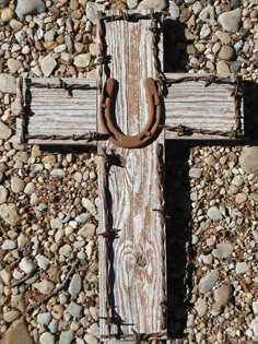 an old wooden cross on some rocks and gravel