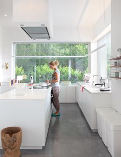 a woman standing in a kitchen next to a window