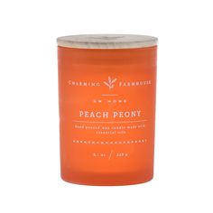 an orange candle that says peach peony on the front and white writing on the back