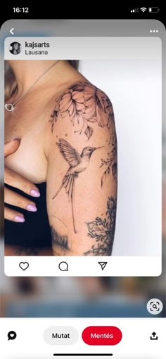 the back of a woman's shoulder with flowers on it and a humming tattoo