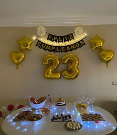 a table topped with balloons and desserts next to a sign that says twenty two