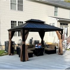 a gazebo sitting on top of a patio next to a house