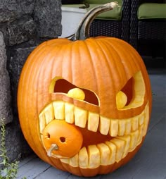 a pumpkin carved to look like a monster with its mouth open and teeth wide open