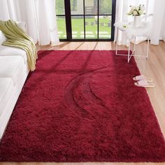 a living room with a red rug and white furniture