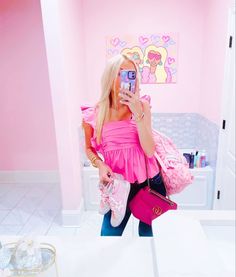 a woman taking a selfie in a pink bathroom