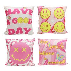 four pillows with smiley faces on them, one pink and the other white in different colors