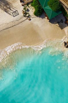 an aerial view of a beach with blue water