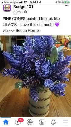 a vase filled with purple flowers on top of a wooden table