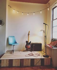 an electric guitar is sitting on top of a wooden platform in front of a window