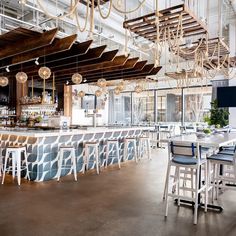 an empty bar with lots of chairs and lights hanging from the rafters above it