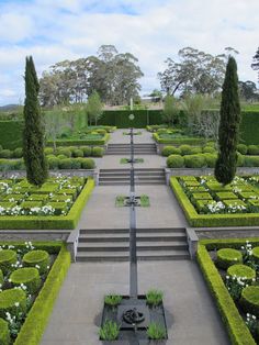 an outdoor garden with many hedges and trees