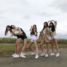 four girls are posing in front of the camera