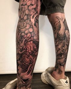 a man's legs with tattoos on them and his leg is covered in black ink