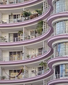 an apartment building with balconies and plants on the balconies are painted purple