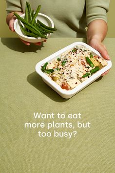 a woman holding a plate with food on it and the words want to eat more plants, but too busy?