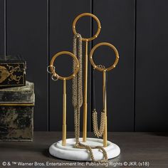 a gold and white jewelry stand on top of a wooden table