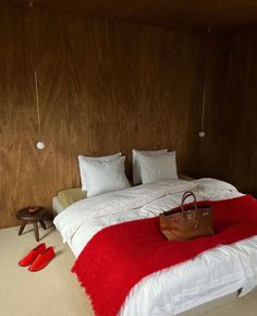 a red and white bed in a room with wooden walls