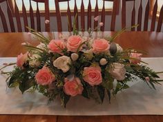 a bouquet of pink and white flowers sitting on top of a table