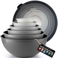 a stack of gray bowls with white dishes in them