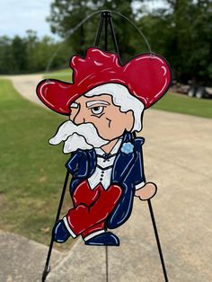 a wind chime with an image of a man wearing a red hat and holding a heart