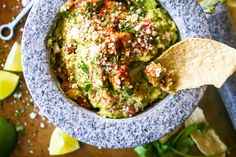 a bowl filled with guacamole and topped with a tortilla chip