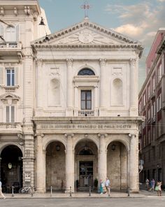 people walking in front of an old building